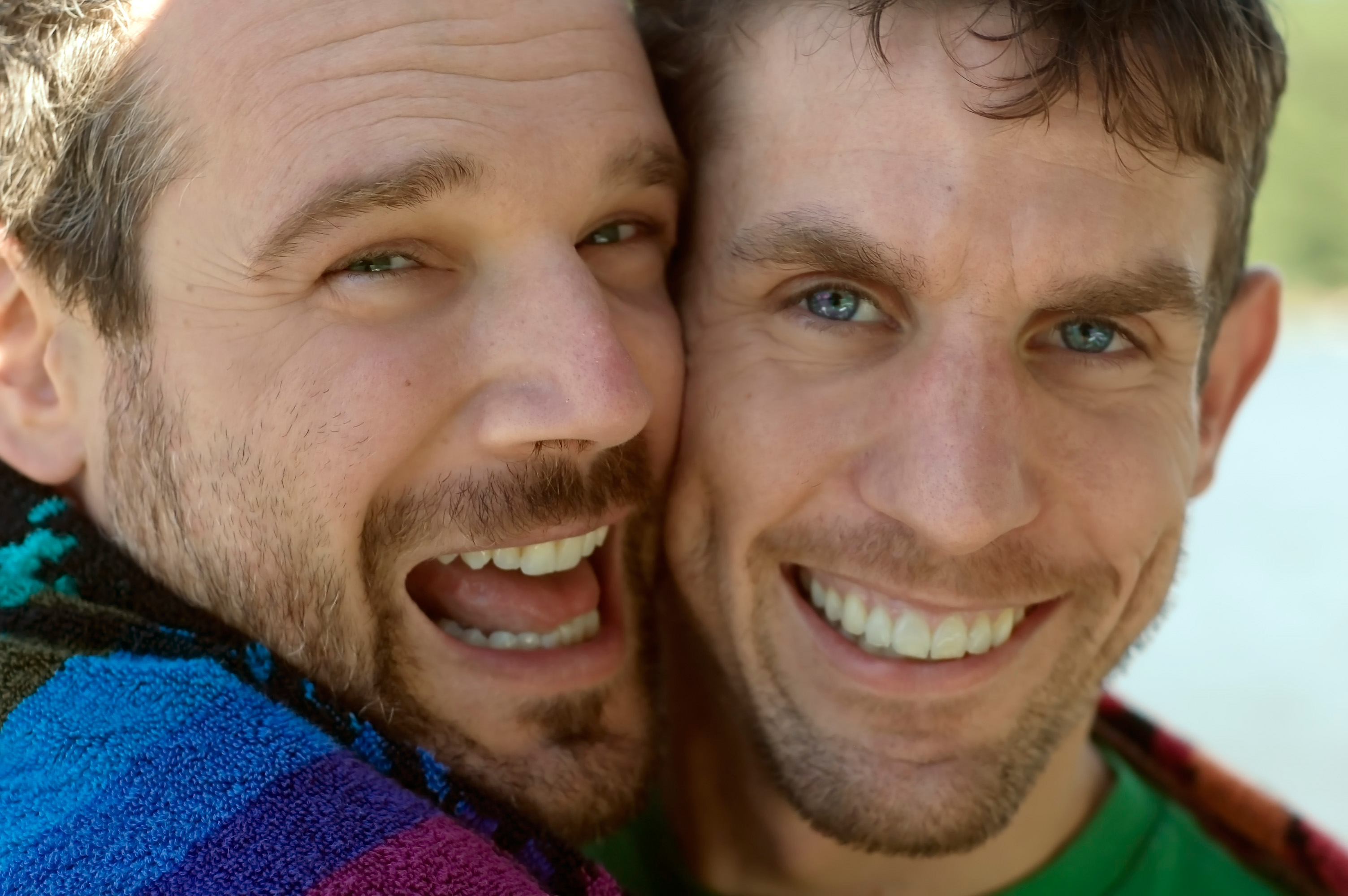 Zwei umarmende Männer die lächelnd in die Kamera blicken