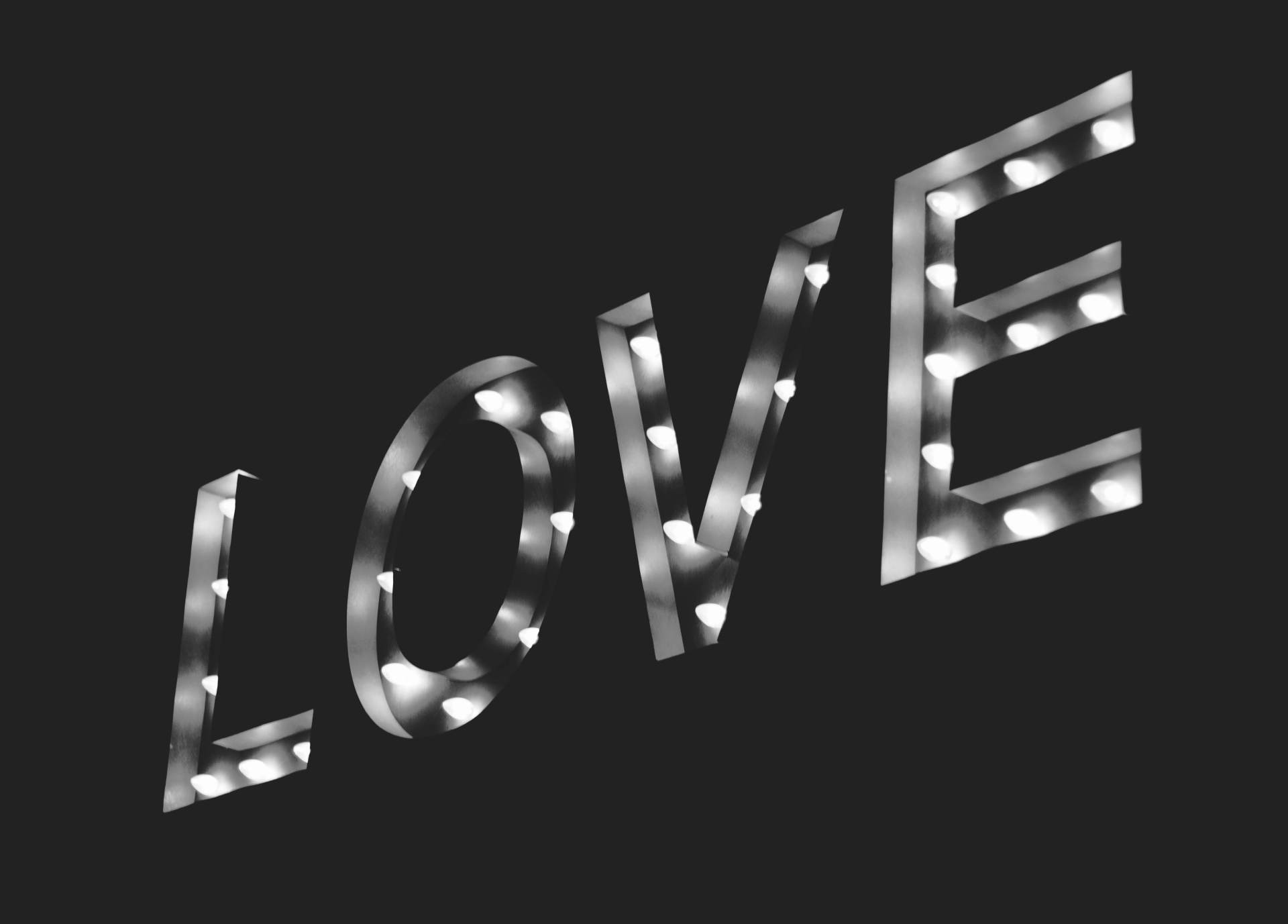 Ein beleuchtetes Schild mit dem Wort "LOVE" (Liebe) symbolisch für Liebe, sich lieben, Sex & Swinger