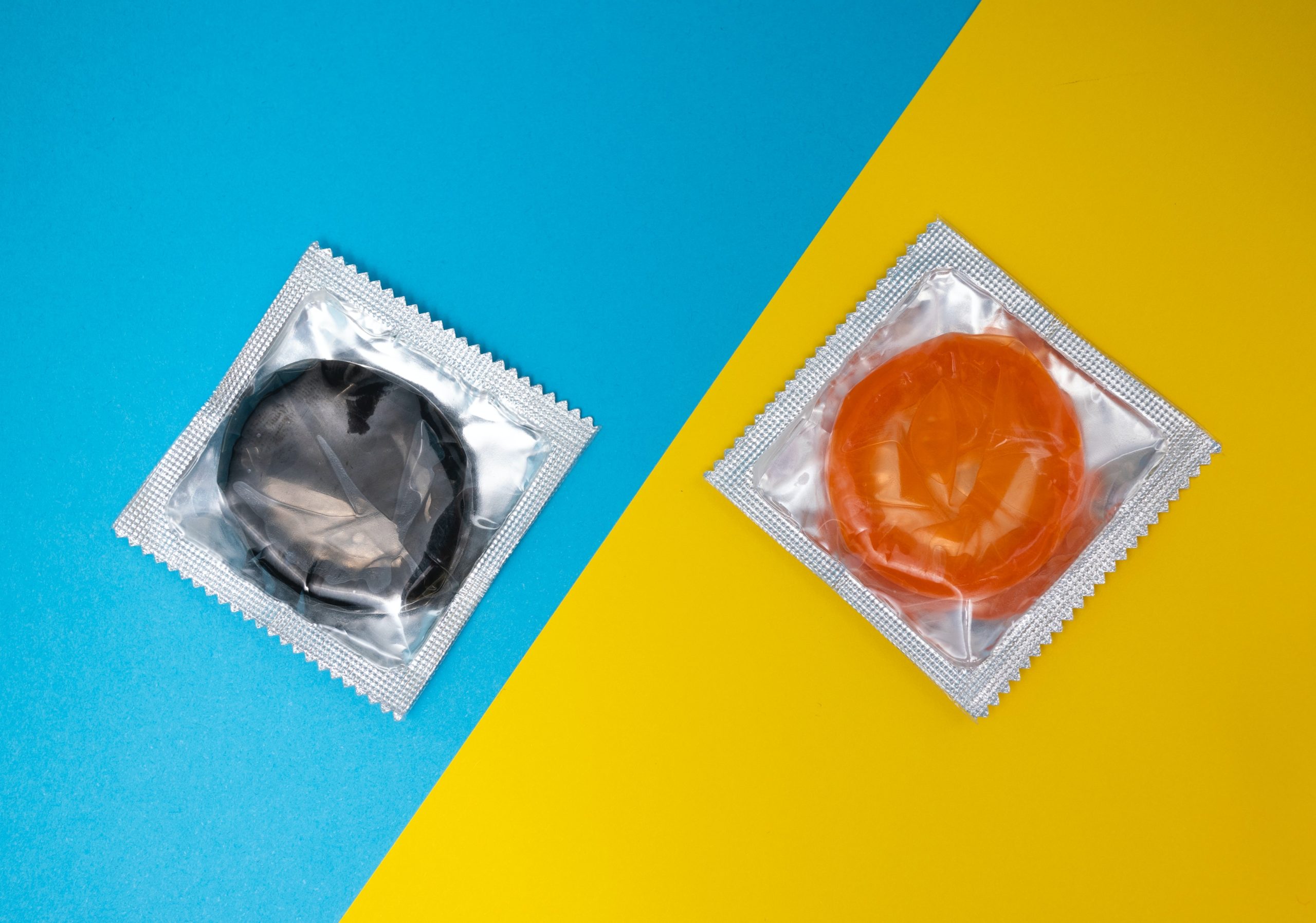 kondome-auf-blau-und-gelb-wissen-ueber-STI-macht-liebe-und-sex-mit-sicherheit-besser