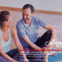 Älteres Pärchen sitzt lachend auf Yogamatte