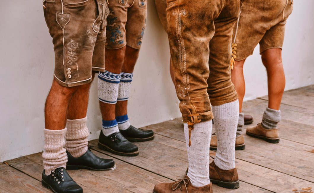 Mehrere Männerbeine in Lederhosen und Wadenstrümpfen.