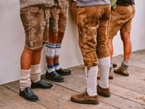 Mehrere Männerbeine in Lederhosen und Wadenstrümpfen.