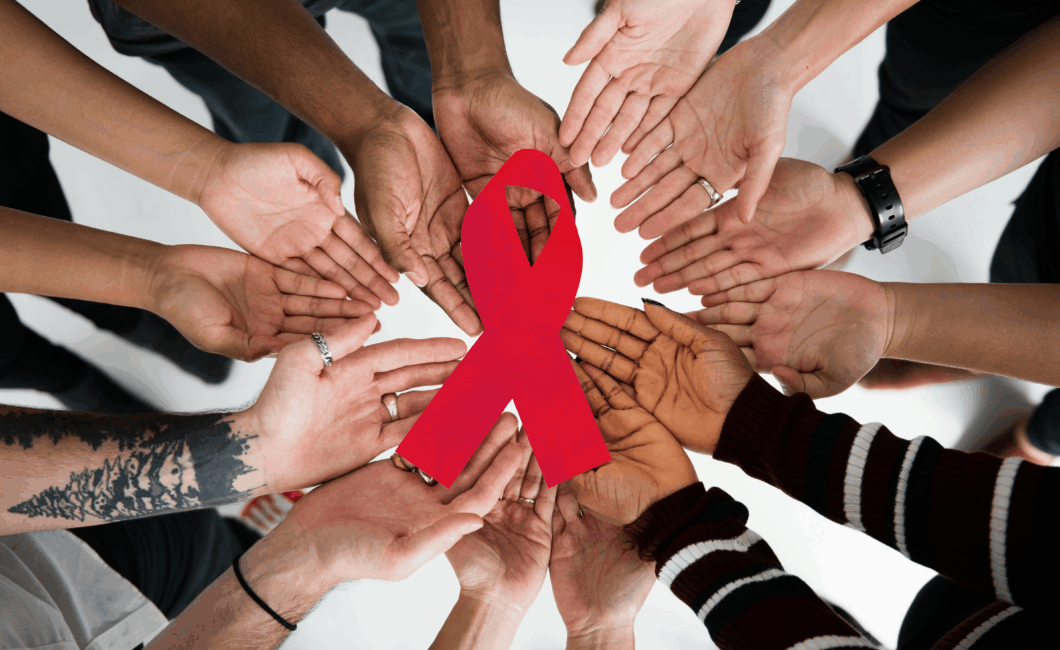 Viele Hände hälten eine Aids-Schleife