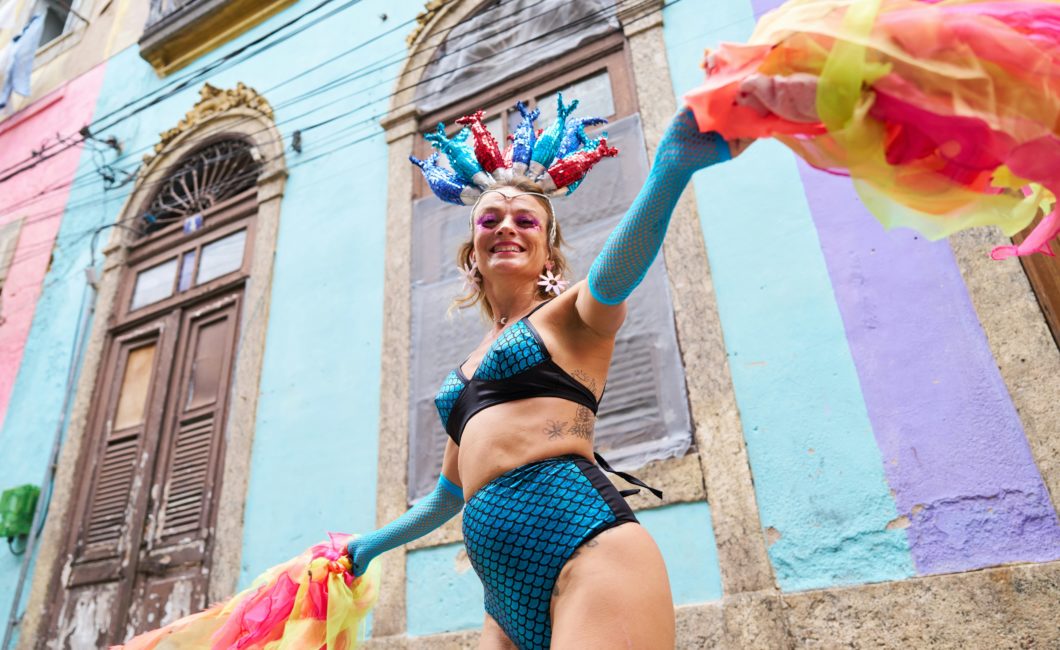 Dame in buntem Faschings-Kostüm schaut lachend in die Kamera