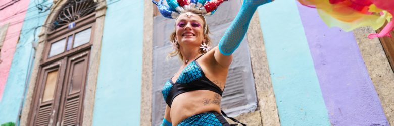 Dame in buntem Faschings-Kostüm schaut lachend in die Kamera